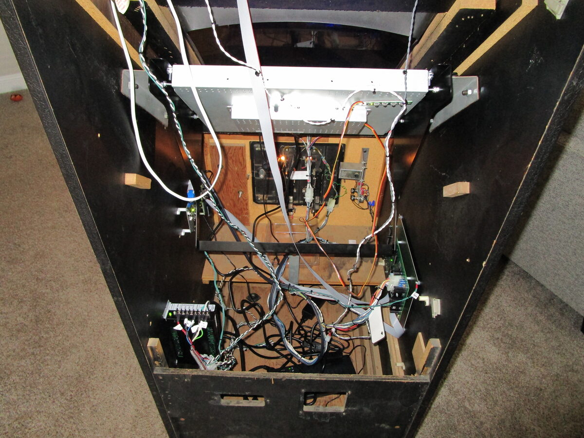 Inside the open arcade cabinet — a dense bundle of wiring connecting the new control boards