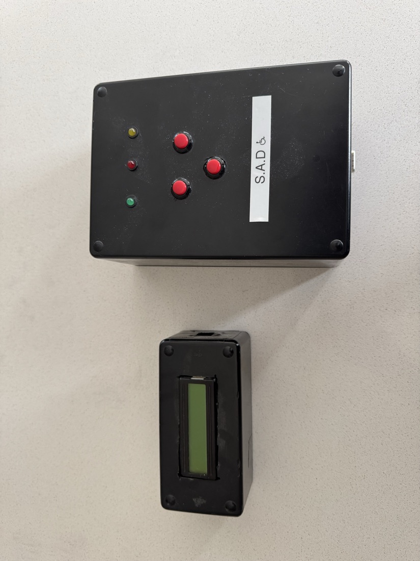 The finished S.A.D — a black project-box base unit with status LEDs and three red buttons, above a separate dashboard LCD module