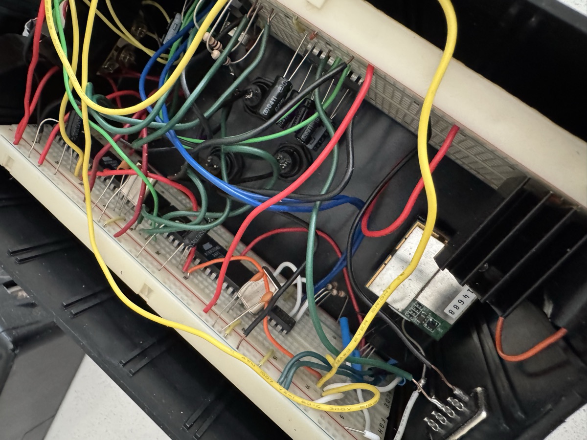 Inside the base unit — a dense rat's nest of colored jumper wires across breadboards, with the silver GPS module at lower right
